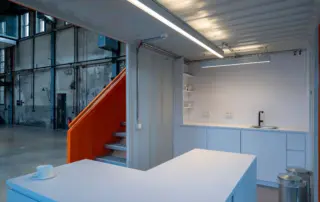 Schlichte weiße Küche in einem Container in einer Lagerhalle.
