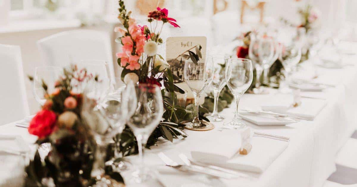 Ein festlich gedeckter Tisch mit Blumenarrangements von Benz-Catering in Stuttgart.