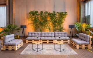 Lounge in der Eventlocation Raum80. Gemütliche Sofa Ecke mit indirekter Beleuchtung und Pflanzen.